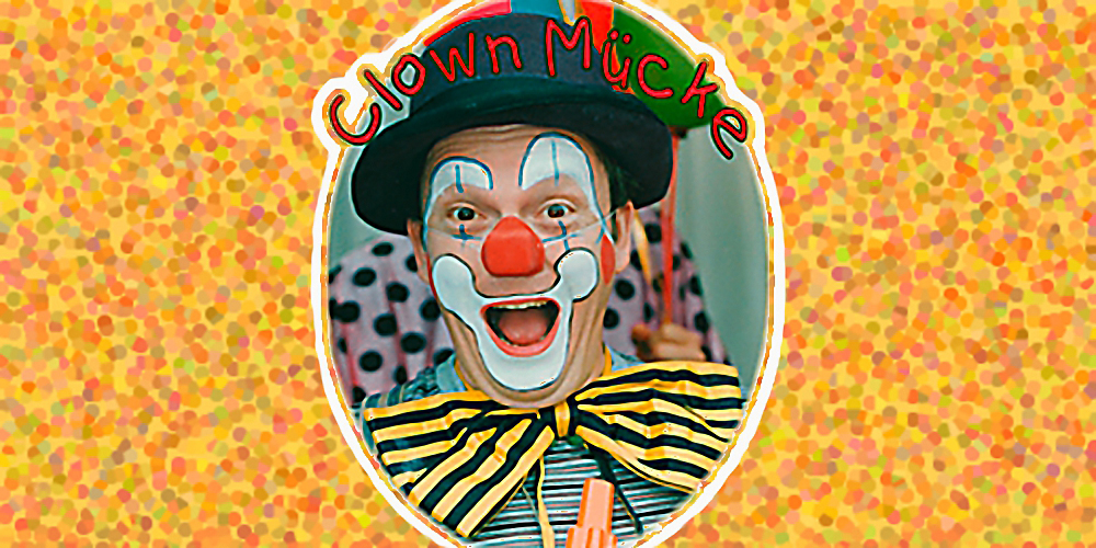 Clown Mücke lacht geschminckt und mit Hut in die Kamera